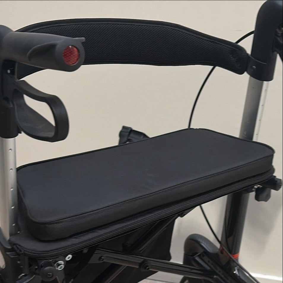 Photo of Rehasense rollator with black comfort seat attached, showing the base board and cushion that velcroes on top; cream back ground