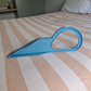 Blue plastic tool on a bed with striped bedding