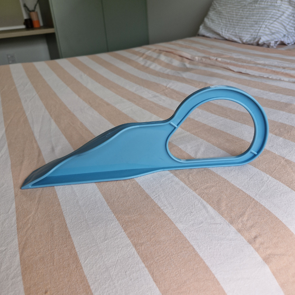 Blue plastic tool on a bed with striped bedding