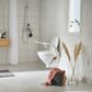 Bathroom with wooden vanity, shower, and Etac My-loo raised toilet seat on toilet
