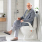 Man using Etac My-loo raised toilet seat in a modern bathroom.