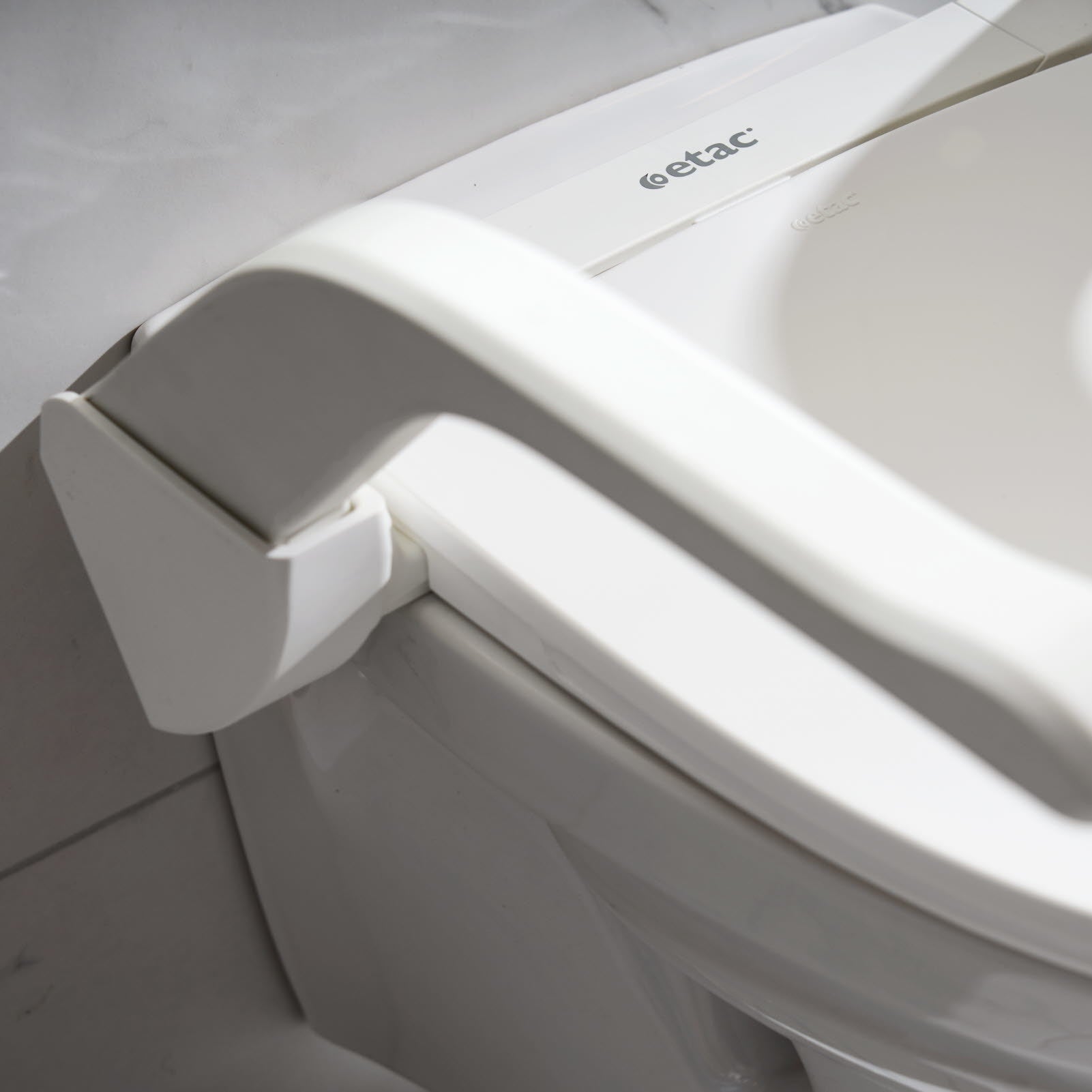 Close up of armrest and lid on Etac My-loo raised toilet seat